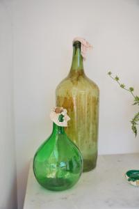 two green glass bottles sitting on a table at Dimora Storica Villa Pasquale Capri in Capri