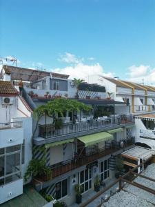 an apartment building with a balcony with trees on it at Pensión El Alamo in Lepe