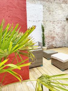 un patio con plantas y una pared roja y blanca en La suite Carthagène des Indes - centre ville , spa & terrasse privée, en Béthune