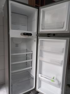 una nevera vacía con la puerta abierta en una cocina en Apartamento Superior, en Balneário Camboriú