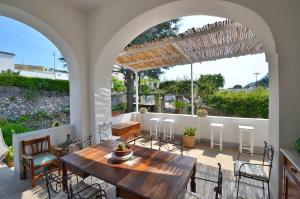 an outdoor patio with a wooden table and chairs at Dimora Storica Villa Pasquale Capri in Capri
