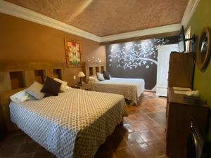 a hotel room with two beds in a room at Hotel Ana Catalina and Suites in San Miguel de Allende