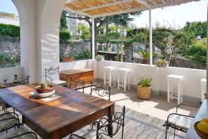 an outdoor patio with a wooden table and chairs at Dimora Storica Villa Pasquale Capri in Capri