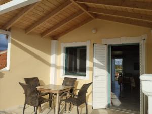 a patio with a table and chairs on a porch at Splantza Apartments in Ammoudia