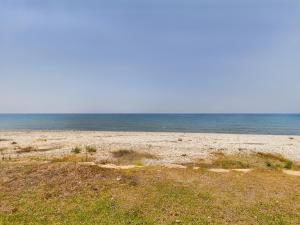 a sandy beach with the ocean in the background at Amazing frontline beach villa in Larnaca