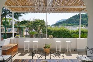 a patio with a table and chairs and a large window at Dimora Storica Villa Pasquale Capri in Capri