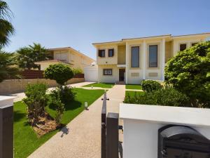 a house with a fence and a yard at Amazing frontline beach villa in Larnaca