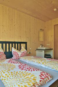 two twin beds in a room with wooden walls at Bergreich Appartement 1 in Schoppernau