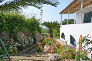 a garden in front of a white house with flowers at Dimora Storica Villa Pasquale Capri in Capri