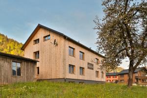 a barn with a clock on the side of it at Bergreich Appartement 1 in Schoppernau