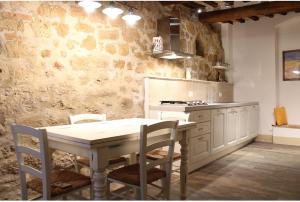a kitchen with a table and chairs in a room at Camere La Carbonaia in Pienza