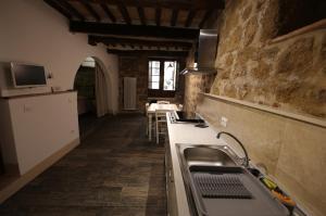 uma cozinha com um lavatório e uma bancada em Camere La Carbonaia em Pienza