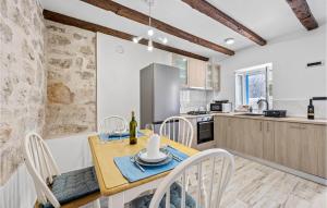 a kitchen and dining room with a table and chairs at Amazing Home In Zlarin With Outdoor Swimming Pool in Zlarin