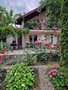 a garden in front of a house with flowers at Casa Jan Bonca in Lorău