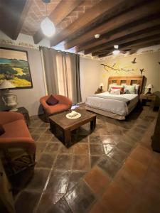 sypialnia z łóżkiem, stołem i krzesłami w obiekcie Hotel Ana Catalina and Suites w mieście San Miguel de Allende