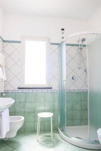 uma casa de banho com um chuveiro, um WC e um banco em Hotel La Luna em Ischia