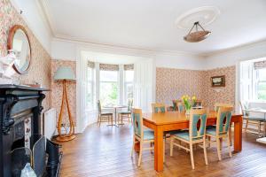 a dining room with a wooden table and chairs at Mansewood Country House in Lochearnhead