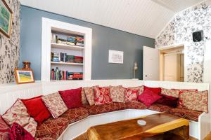 a living room with a couch with red pillows at Mansewood Country House in Lochearnhead