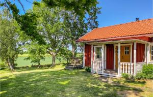 ein rotes Haus mit einem orangenen Dach und einem Hof in der Unterkunft Stunning Home In Kalmar With Kitchen in Kalmar