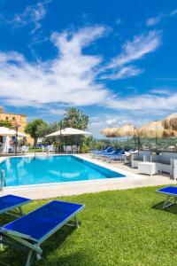 伊斯基亞的住宿－拉盧納酒店，一个带躺椅和遮阳伞的游泳池