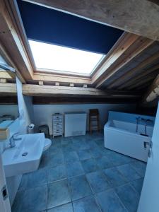 a bathroom with two sinks and a tub and a skylight at Monti D'Abruzzo holiday home in Crecchio