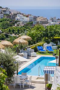 a pool with chairs and tables and umbrellas at Hotel La Luna in Ischia