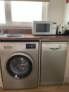 a kitchen with a microwave and a washing machine at Central London apartment in London