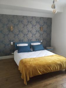 a bedroom with a large bed with blue wallpaper at L'ÉCHAPPÉE BELLE in Capdenac-Gare