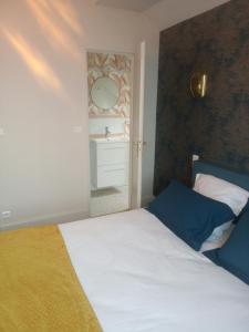 a bedroom with a bed and a bathroom with a sink at L'ÉCHAPPÉE BELLE in Capdenac-Gare