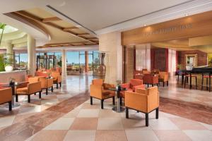 un restaurant avec des tables et des chaises dans un hall dans l'établissement Sheraton Fuerteventura Golf & Spa Resort, à Caleta de Fuste