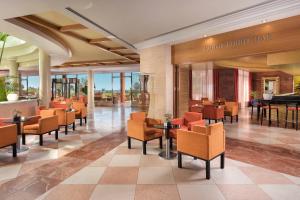 een restaurant met tafels en stoelen in de lobby bij Sheraton Fuerteventura Golf & Spa Resort in Caleta De Fuste