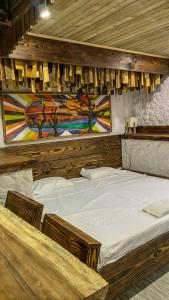 two beds in a room with a painting on the wall at Hotel Cabañas Club Sierra Limón in Santa Marta