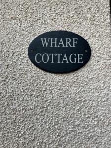 ein schwarzes Schild mit der Aufschrift „Was für ein Kaffee“ an einer Wand in der Unterkunft Wharf Cottage in Coalbrookdale + 1 Foto