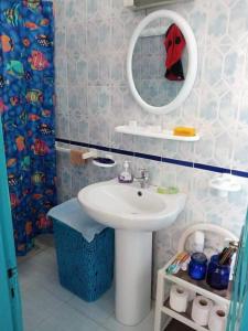 ein Bad mit einem Waschbecken und einem Spiegel in der Unterkunft Bungalow Djerbien in Midoun