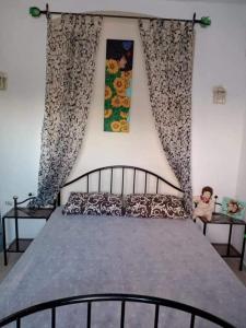 Un dormitorio con una cama grande con cortinas y un niño sentado en una mesa. en Bungalow Djerbien en Midoun