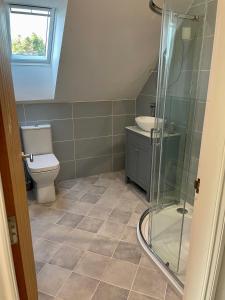 een badkamer met een toilet en een glazen douche bij Còsagach Flat near Oban in Barcaldine
