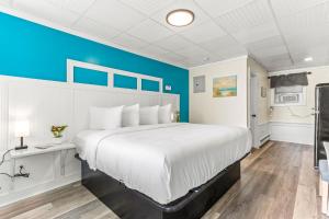een slaapkamer met een groot bed en een blauwe muur bij Royal Crest Inn - Hampton Beach in Hampton