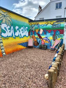 a mural on a building with chairs in front of it at Sea Shells in Torquay