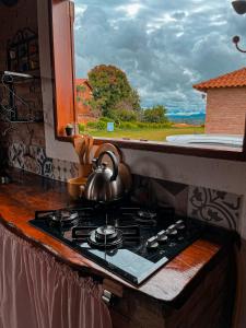 a tea kettle on top of a stove in a kitchen at Chalés Bela Vista in São Thomé das Letras