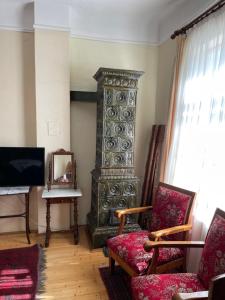 ein Wohnzimmer mit einem TV, einem Stuhl und einem Klavier in der Unterkunft Hajós-ház in Szeged