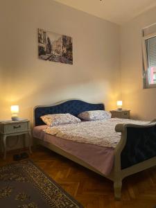 - une chambre avec un lit bleu et 2 tables de nuit dans l'établissement DOLCE APARTMAN, à Podgorica