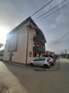 un edificio con auto parcheggiate di fronte di Apartman 11 a Leskovac