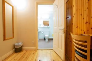 a bathroom with a toilet and a hallway with a door at Cozy Retreat by Shortstays in Westport