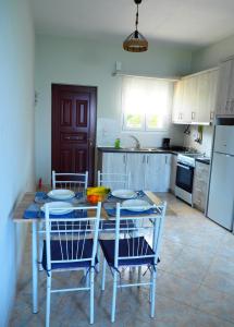 a kitchen with a table and chairs and a kitchen with at TSOUMAS HOUSE in Kastrosikia