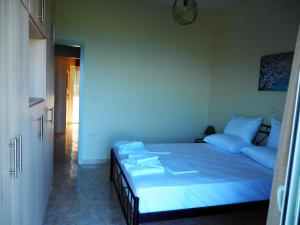 a bedroom with a large bed with blue sheets at TSOUMAS HOUSE in Kastrosikia