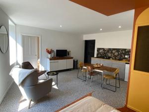 a living room with a table and chairs and a kitchen at LE CARNOT - Valence in Bourg-lès-Valence