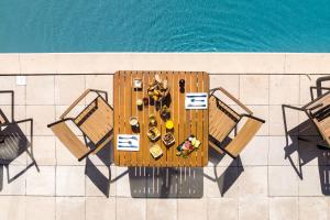 een tafel en stoelen boven het zwembad bij Hôtel Ile de Ré in Le Bois-Plage-en-Ré