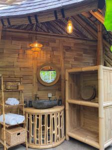 un baño en una casa de madera con lavabo en Wahem Eco Bamboo, en Ubud
