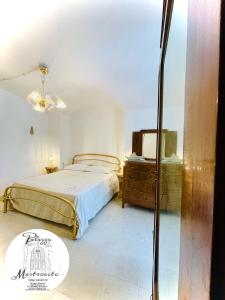 una camera con letto, cassettiera e specchio di Palazzo Mastrovito a Martina Franca
