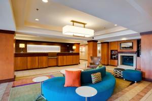 a living room with a blue couch and a kitchen at Fairfield Inn and Suites South Hill I-85 in South Hill